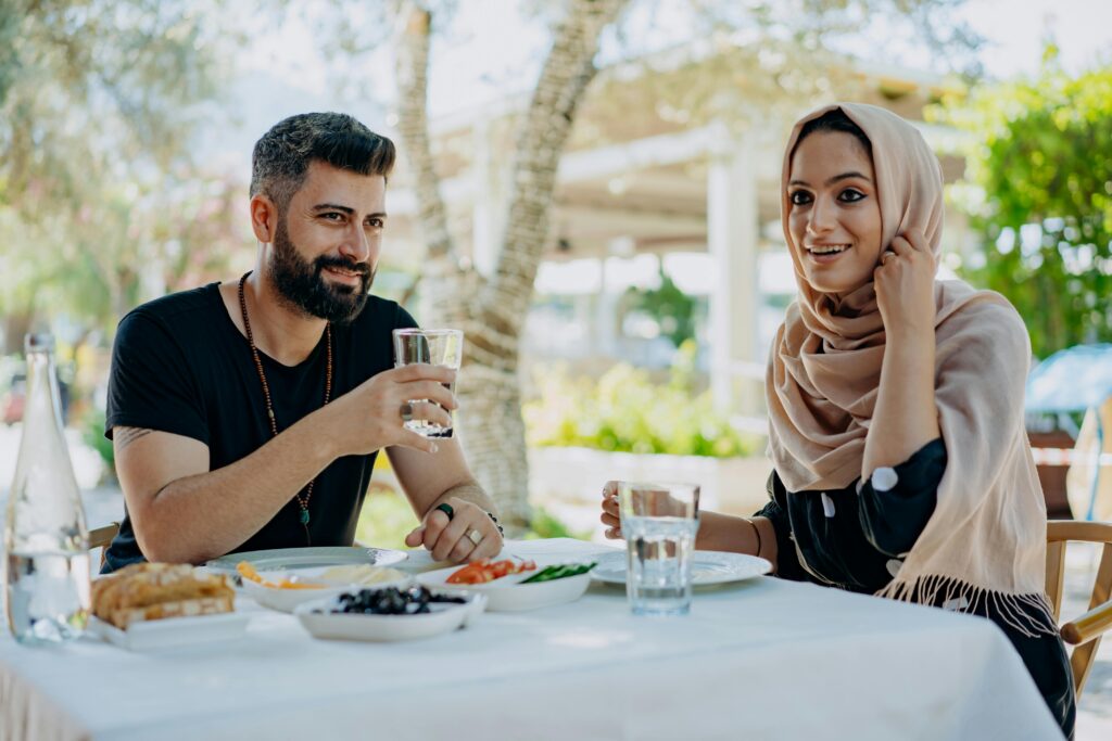 A couple having a cheerful lunch outdoors at a restaurant.